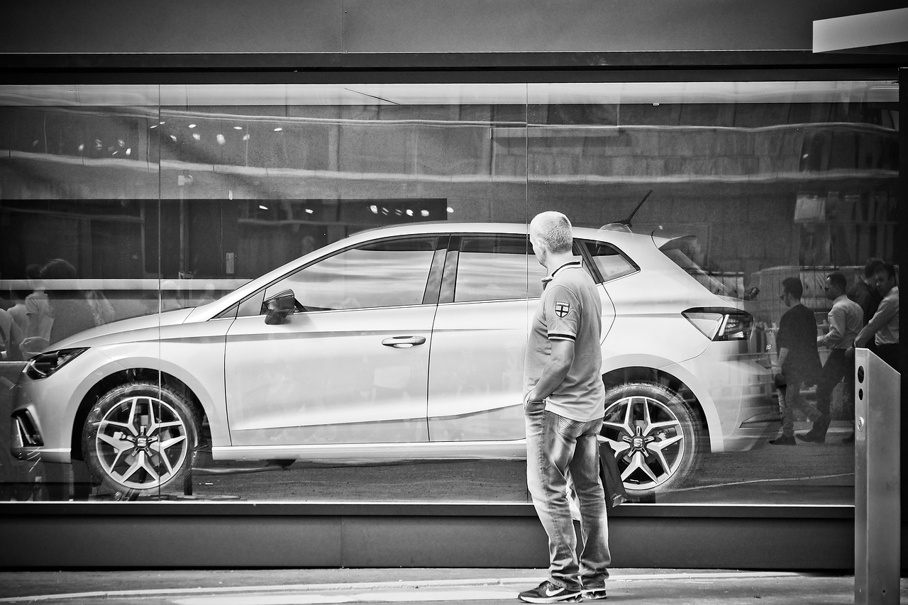 man standing by car considering